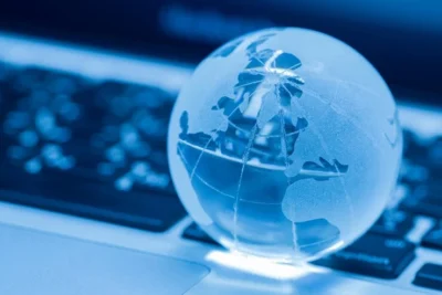 Globo de vidro sobre teclado de laptop, simbolizando SEO Internacional e a conexão mundial pela internet. Ideal para estratégias digitais globais.