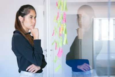 Pessoa analisando estratégia de marketing de influência em crise, com post-its coloridos na parede, destacando a importância da autenticidade na era da desconfiança