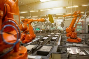 Imagem de uma fábrica moderna com robôs industriais automatizados representando a Indústria 4.0, mostrando tecnologia avançada, automação e inovação no setor manufatureiro.